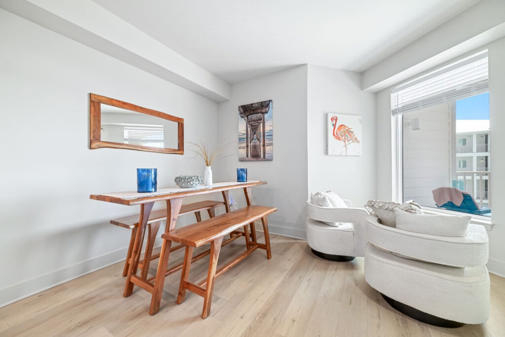 Bright, airy interior featuring a wooden dining table with benches, decorative vases, and art pieces including a flamingo. Ideal for modern decor insights.